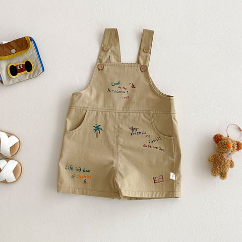 Beige overalls with embroidered text and graphics on a light background