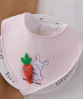 Pink baby bib with cartoon designs on a white background