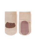 Pair of beige socks with a brown bear face design on a white background