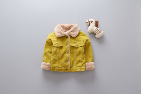 Yellow children's jacket with pink lining and a stuffed animal on a gray background