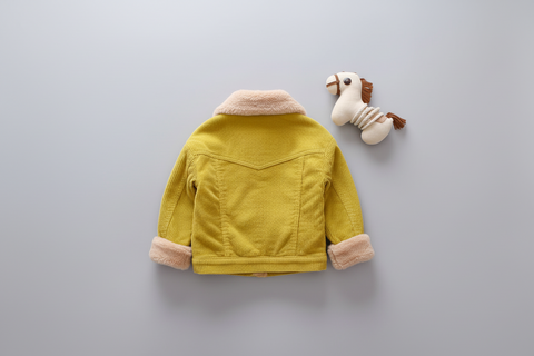 Yellow children's jacket with pink cuffs and collar on a light gray background