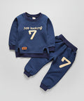 Children's blue outfit with 'Just looking 7' text on a textured surface