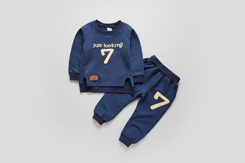 Children's blue outfit with 'Just looking 7' text on a textured surface