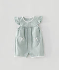 Light green baby romper with heart designs on a light gray background