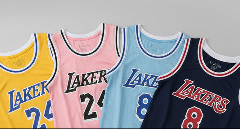 Four Lakers jerseys in different colors with numbers on a white background