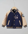 Navy and beige varsity jacket with number 7 on a hanger against a neutral background