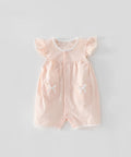 Pink baby romper with heart and bow designs on a light gray background