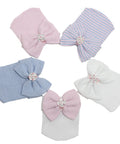 Set of five baby hats with bow accents on a white background