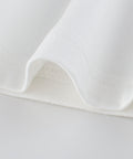 Close-up of white fabric on a light gray background