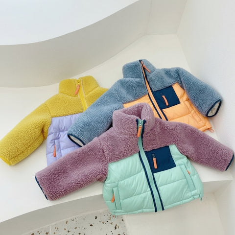 Four colorful children's jackets arranged on a white surface.