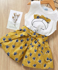 Children's outfit with white top and yellow shorts on a wooden surface