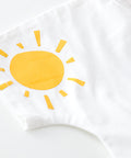 White pillow with a yellow sun design on a white background