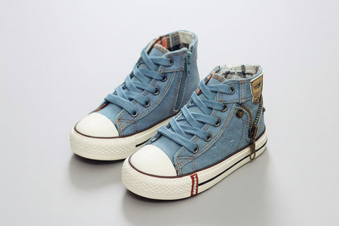 Pair of blue high-top sneakers with white soles on a wooden floor.