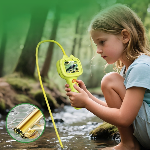 Child holding a yellow device with a screen, examining nature outdoors.