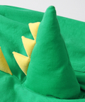 Green dinosaur costume with yellow spikes on a white background