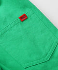 Green shirt pocket with a red label on a white background