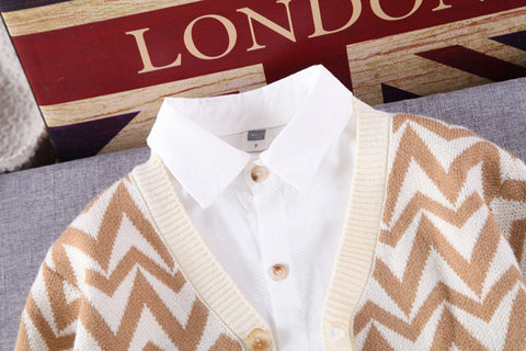 طقم أنيق من قميص أبيض، وسترة صوفية، وبنطال مطاطي