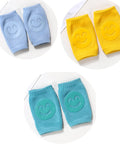 Set of blue, yellow, and teal knee pads with smiley face designs on a white background.
