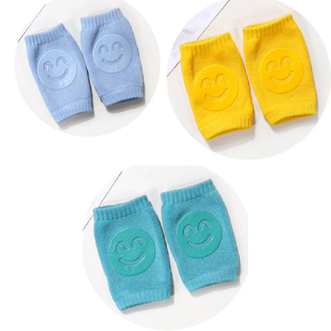 Set of blue, yellow, and teal knee pads with smiley face designs on a white background.