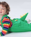 Child wearing a colorful dinosaur costume on a white background
