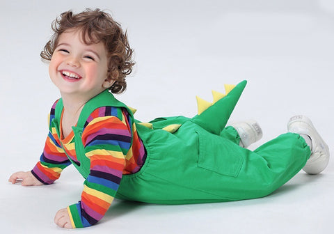 Child wearing a colorful dinosaur costume on a white background