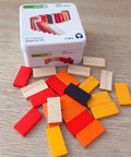 Colorful wooden blocks with a tin box labeled 'Games For Trip' on a wooden surface.