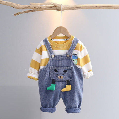 Children's outfit with striped shirt and denim overalls on a hanger against a gray background