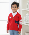 Child wearing a red sweater with animal designs in a room setting