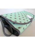 Mint green bag with black polka dots on a light gray background