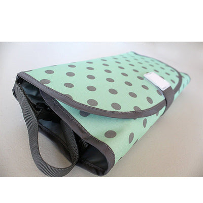 Mint green bag with black polka dots on a light gray background