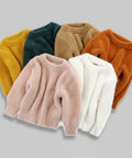 Set of five different colored fluffy sweaters on a white background