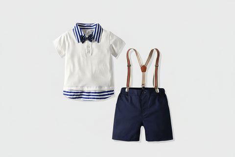Children's outfit with white shirt, navy shorts, suspenders, and bow tie on a white background