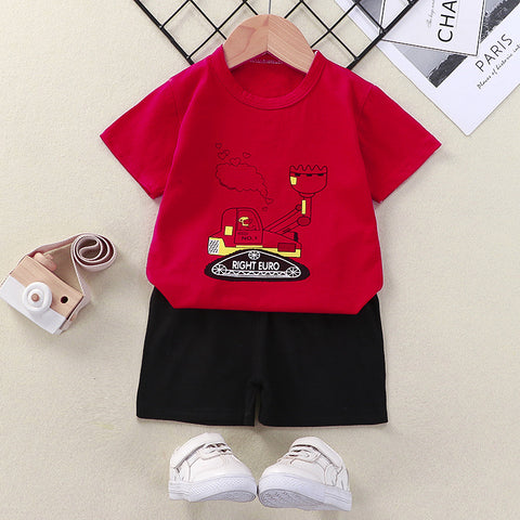 Red t-shirt with a graphic design and black shorts on a beige surface with white sneakers.