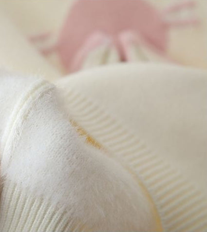 Close-up of a textured white fabric with a blurred pink background