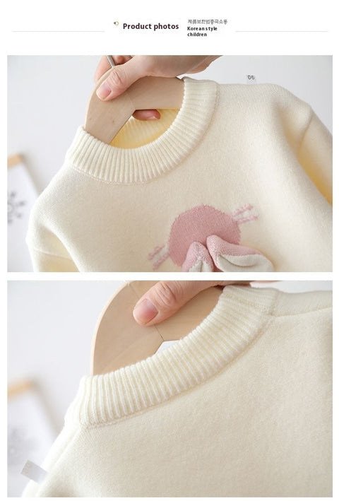 Close-up of a white sweater with a pink design on a white background