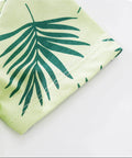 Green fabric with leaf pattern on a white background