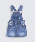 Blue denim overall dress on a white background