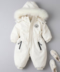 White children's snowsuit with fur hood on a dark marble background