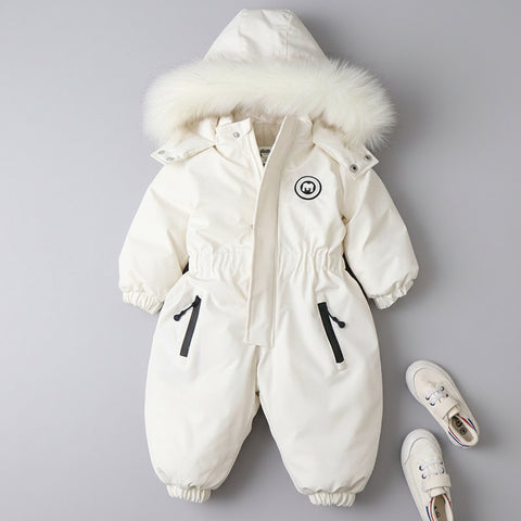White children's snowsuit with fur hood on a dark marble background