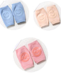 Set of baby knee pads in blue, pink, and peach on a white background