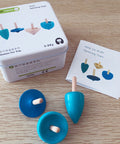 Blue spinning tops with packaging and instructions on a wooden surface