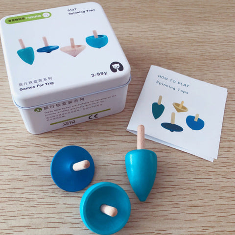 Blue spinning tops with packaging and instructions on a wooden surface