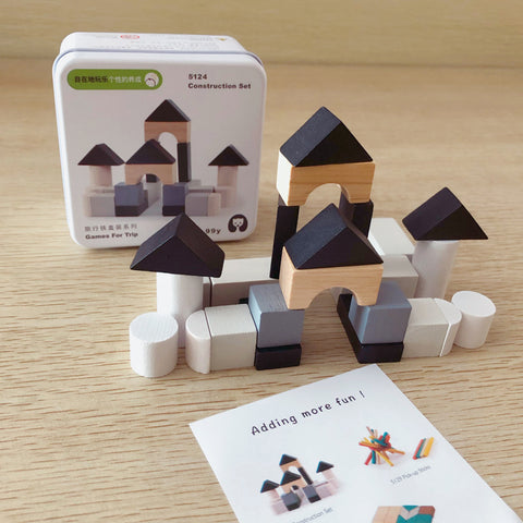 Wooden building blocks set with packaging and instructions on a wooden surface