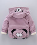 Pink hoodie with bear design on a gray surface