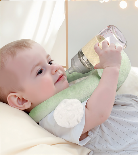 Baby holding a green and white bottle with a textured surface