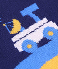 Close-up of a sock with a pixelated truck design on a dark blue background