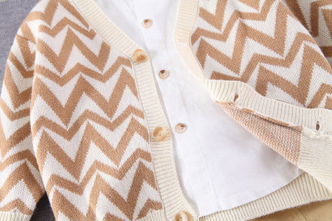 طقم أنيق من قميص أبيض، وسترة صوفية، وبنطال مطاطي