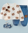 Children's outfit with bear-patterned shirt, blue pants, and shoes on a light blue background