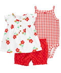 Children's outfit set with floral top, red shorts, and checkered romper on a white background