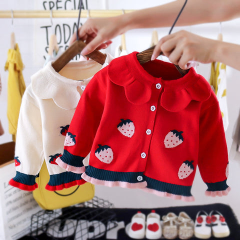 Red children's jacket with strawberry pattern on a hanger